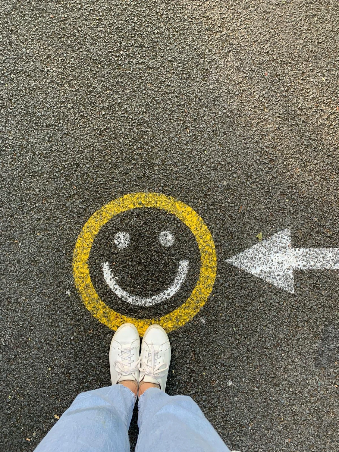 Linelio Personalvermittlung - Eine Draufsicht auf weiße Schuhe, die neben einem gelben Smiley stehen 